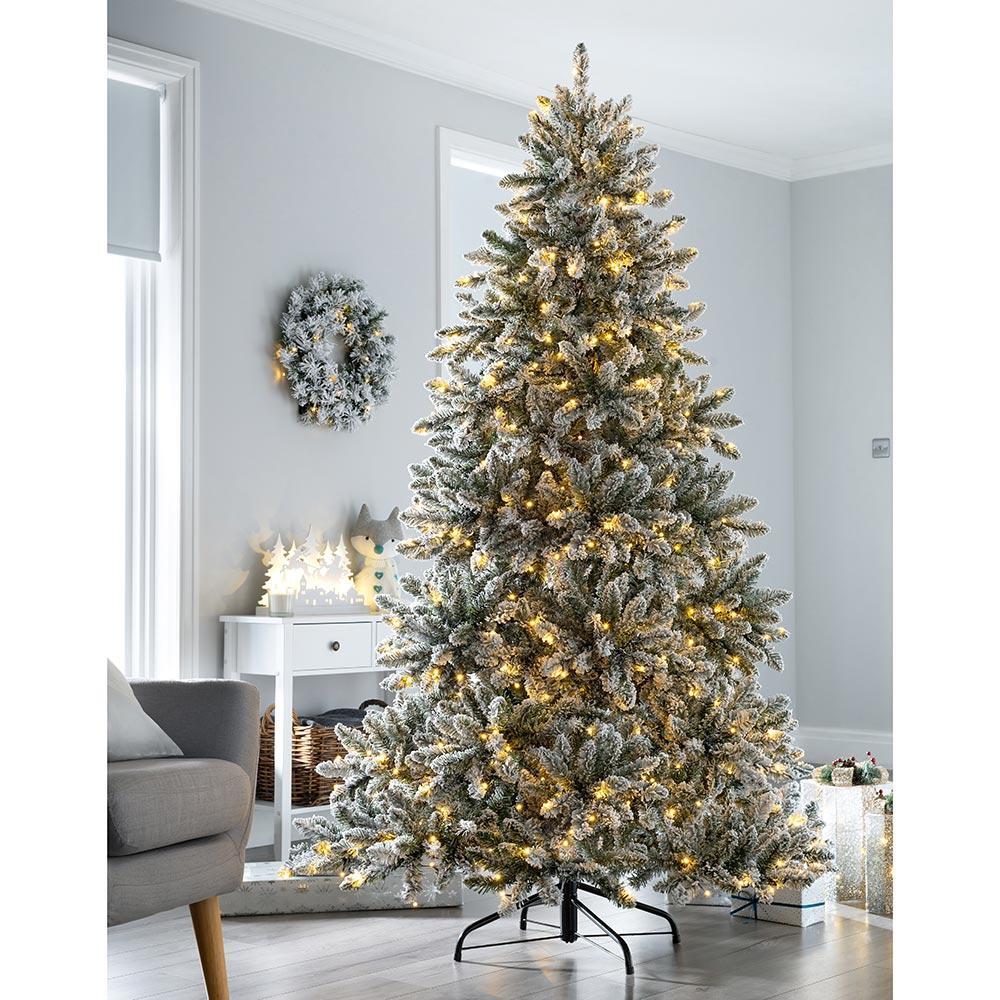 A 7-foot pre-lit full-body snow-planted Christmas tree with LED lights that chase warmth